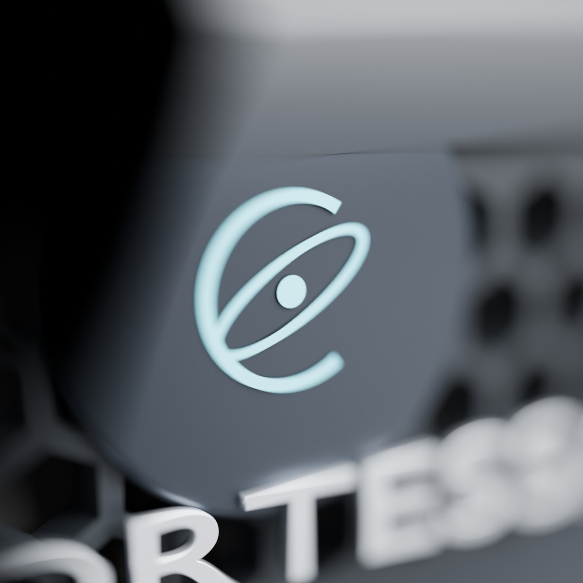 Macro detail of the cyan Cortessa orbital emblem on a machined graphite badge set into the honeycomb.